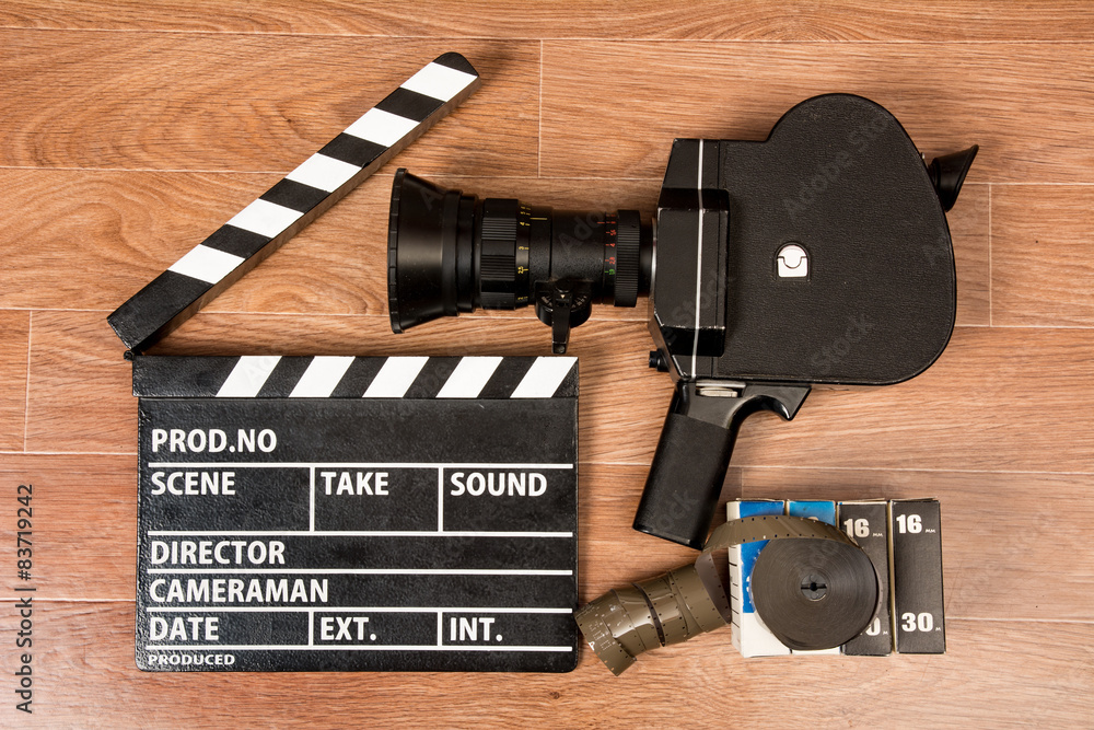 Fototapeta premium Old movie camera with a movie clapper and film.