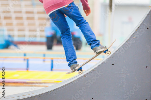 teenager doing a trick by skateboard on a kicker in skate park