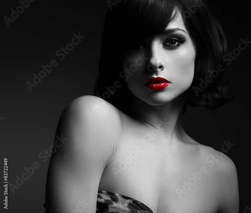 Sexy short hair woman with red lips in darkness. Black and white