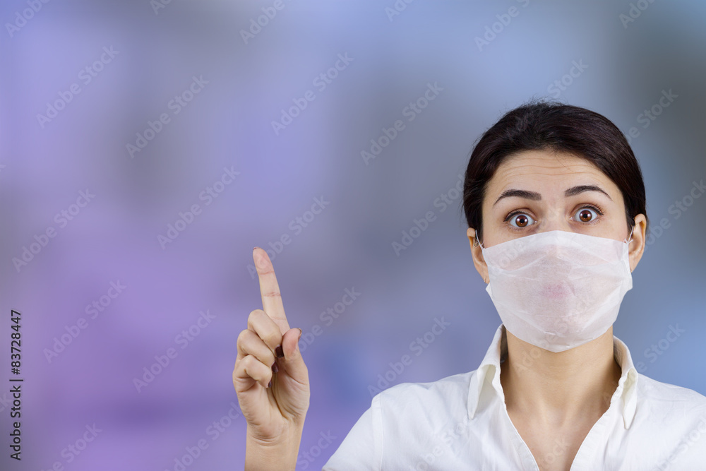 Female doctor with protective mask pointing up Female doctor with protective mask pointing up