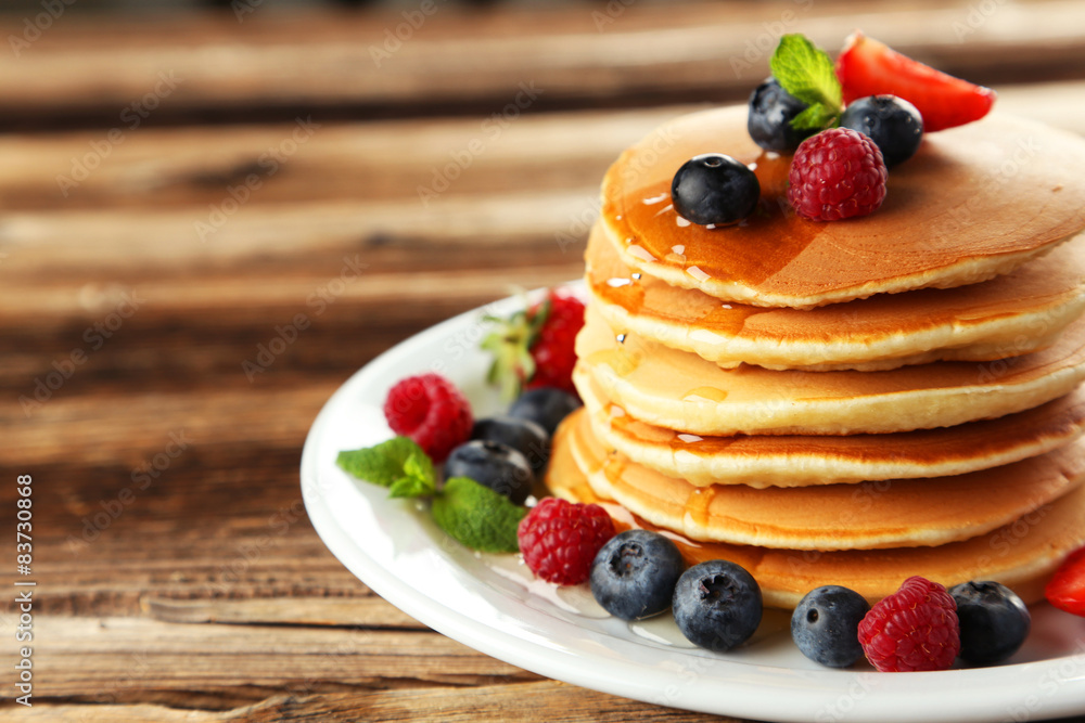 Delicious pancakes with berries on brown wooden background Delicious pancakes with berries on brown wooden background