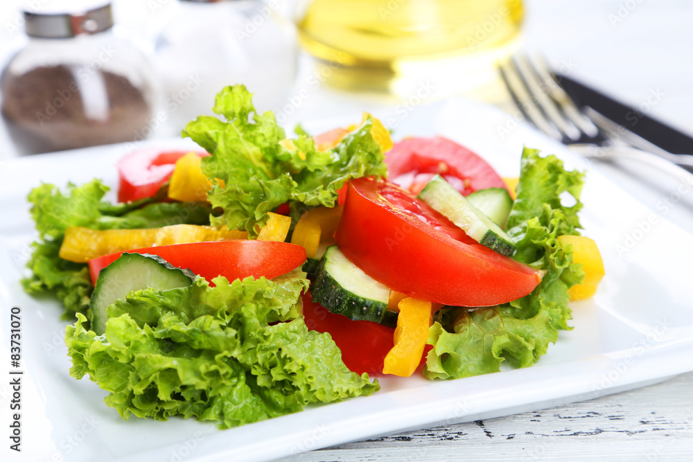 Fresh vegetable salad on white wooden background