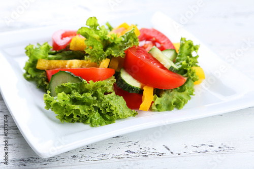Fresh vegetable salad on white wooden background