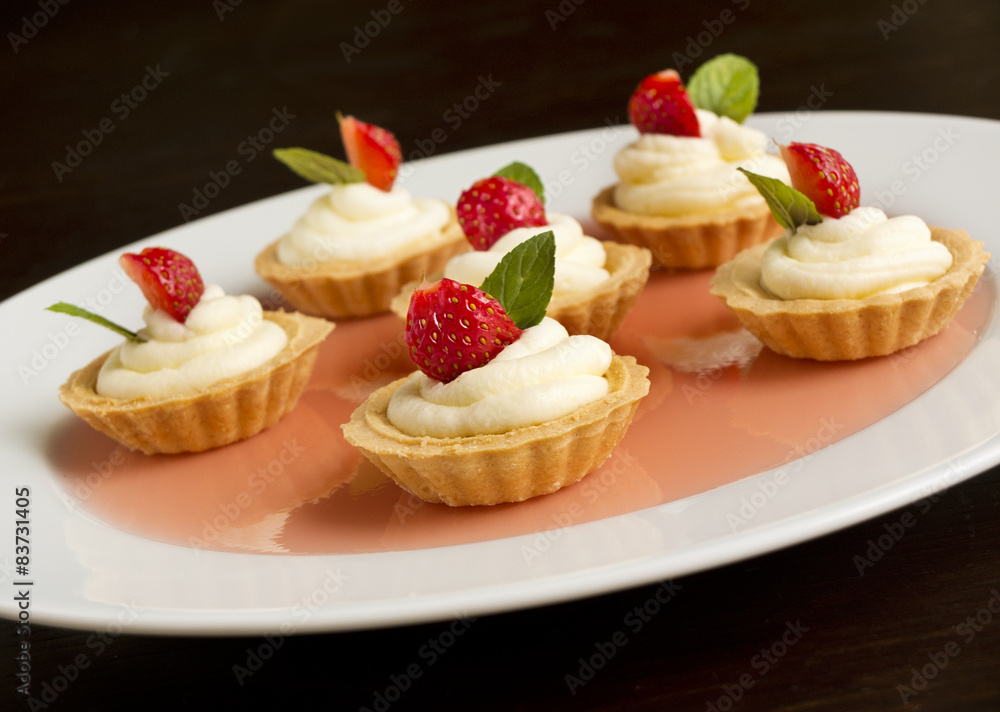 cupcakes with strawberry, whipped cream, jelly and mint