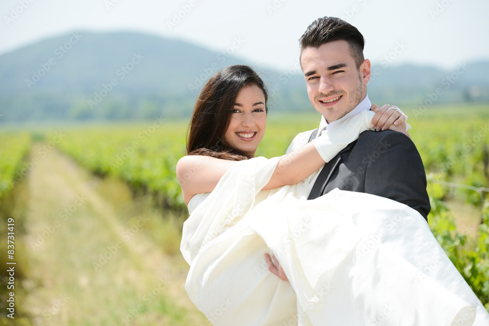 cheerful married young couple running in wheat field