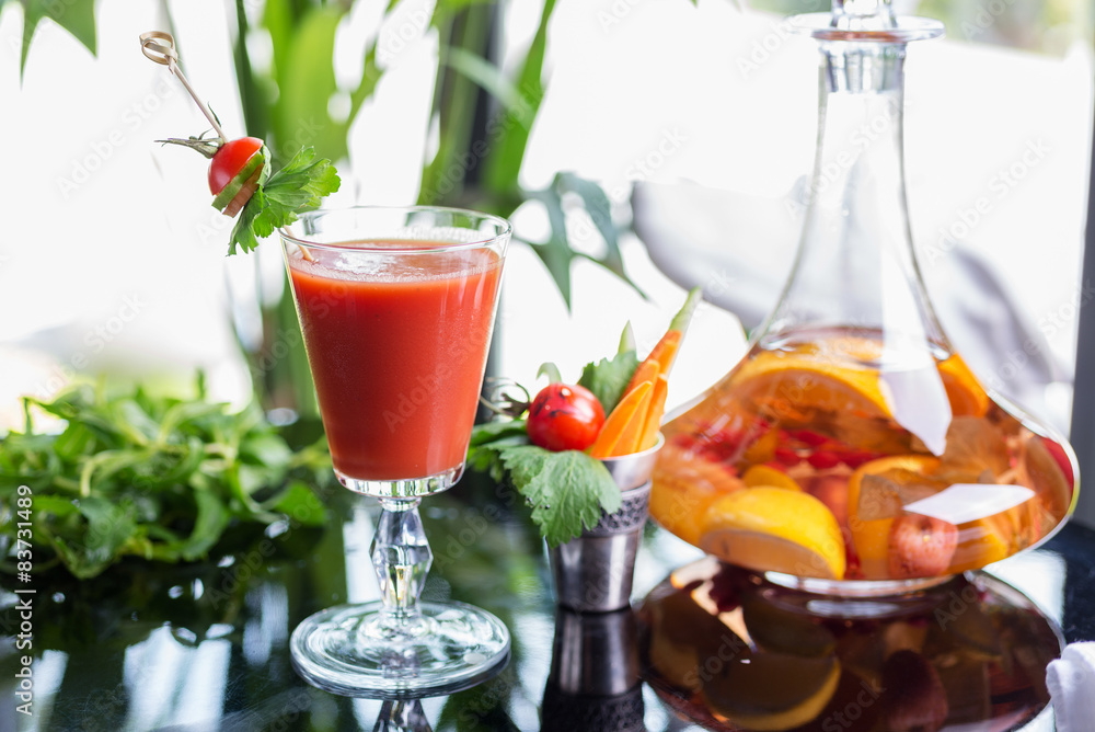 bright summer refreshing alcoholic cocktail Bloody Mary on a table in a restaurant with a creative decoration of cherry pepper greens. soft focus bright summer refreshing alcoholic cocktail Bloody Mary on a table in a restaurant with a creative decoration of cherry pepper greens. soft focus