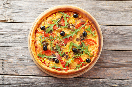 Fresh tasty pizza on grey wooden background