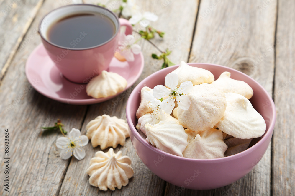 French meringue cookies in bowl on grey wooden background French meringue cookies in bowl on grey wooden background