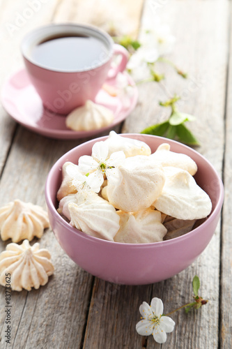 French meringue cookies in bowl on grey wooden background