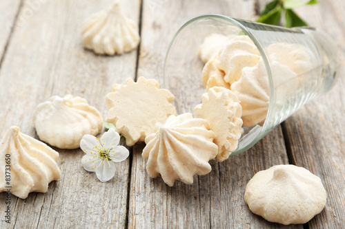 Photos French meringue cookies with glass on grey wooden background