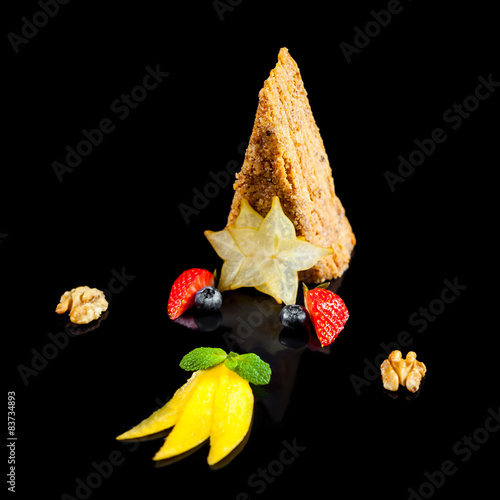 Honey cake with walnuts on a black background