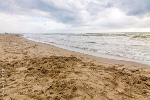 Empty beach and waves  in a cloudy day