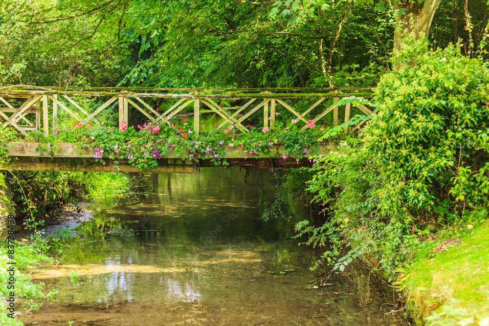 Old small bridge over river in green garden. Old small bridge over river in green garden.