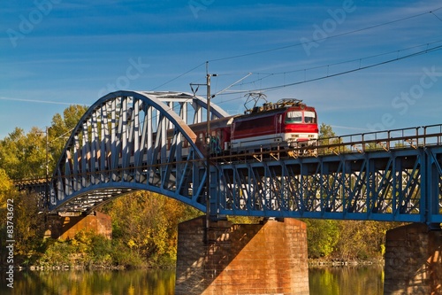 Train on the bridge crossing river .
