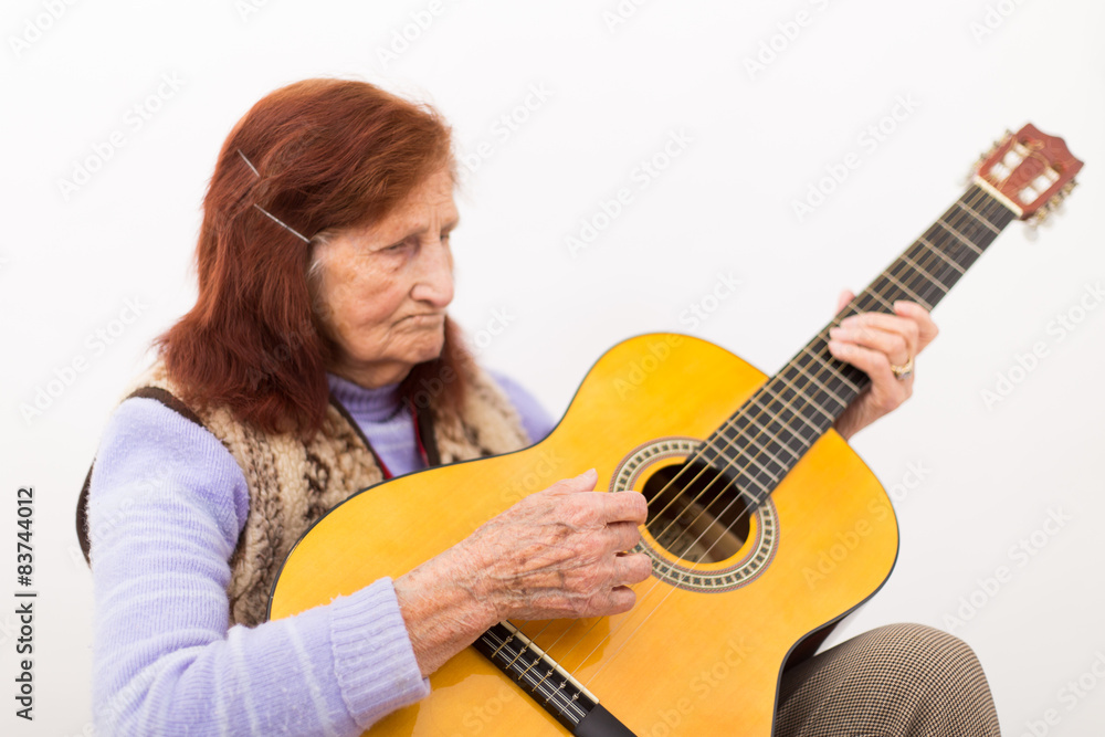 Fototapeta premium Funny elderly lady playing acoustic guitar.