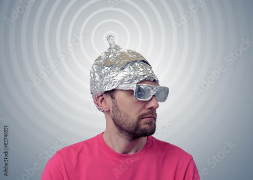 Photography Bearded funny man in a cap of aluminum foil sends signals