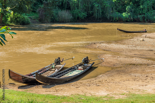 Long tail wooden motorboats in river are vintage water transport photo