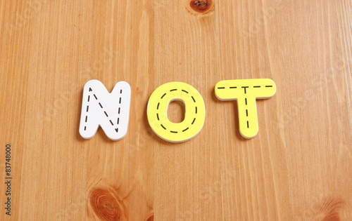 NOT, spell by woody puzzle letters with woody background