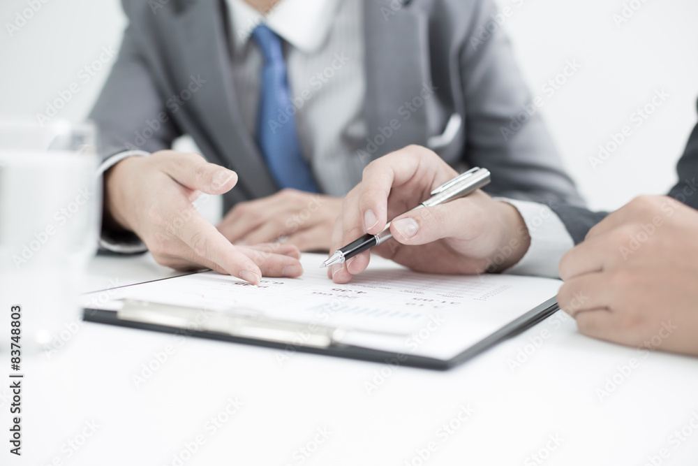 Two businessmen looking at report and having a discussion in off Two businessmen looking at report and having a discussion in off