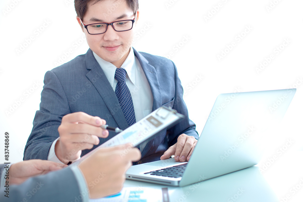 Two businessmen looking at report and having a discussion in off Two businessmen looking at report and having a discussion in off