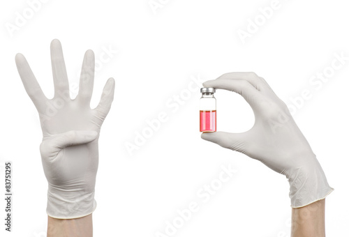 doctor's hand in a white glove holding a red vial of liquid