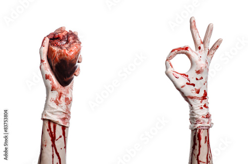 Bloody hand surgeon holding a human heart in a white gloves