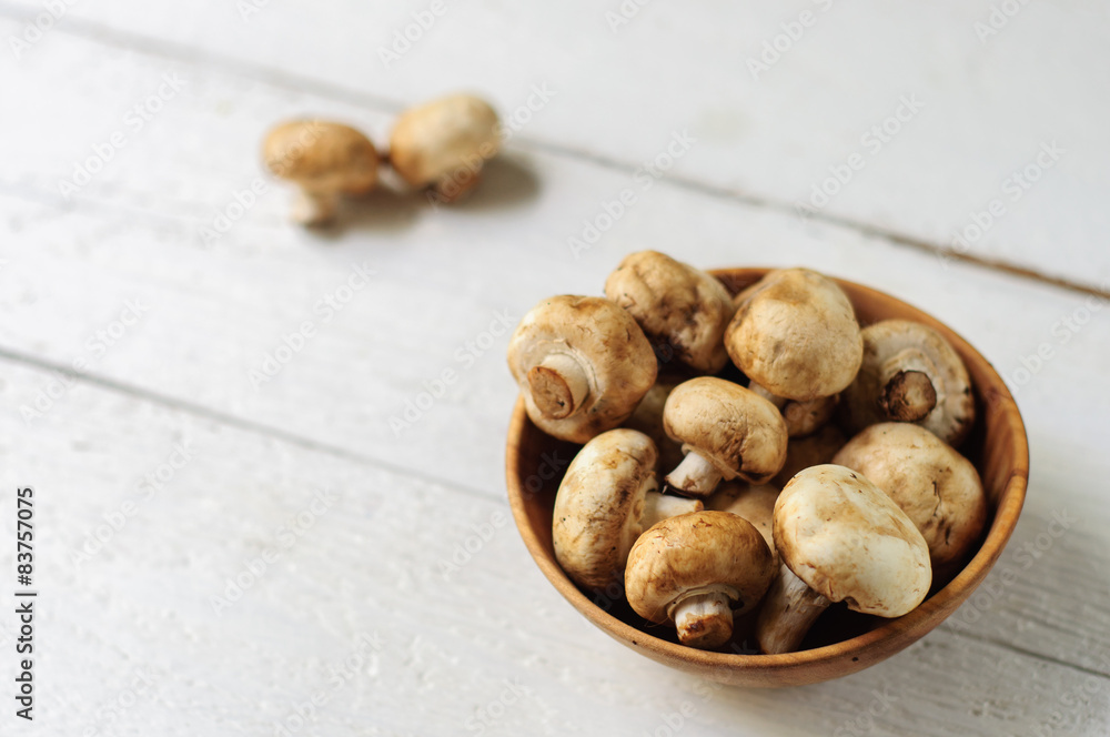 Wooden bowl with fresh champignons Wooden bowl with fresh champignons