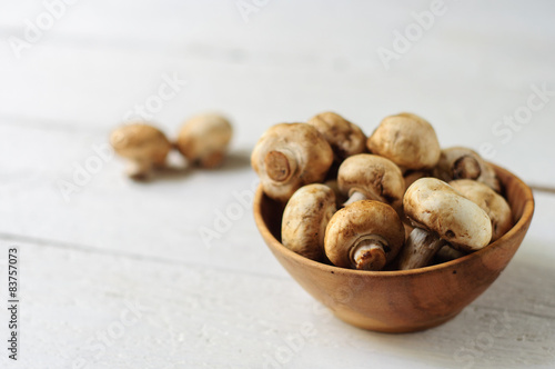 Wooden bowl with fresh champignons