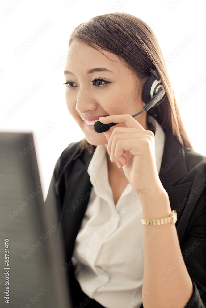 businesswoman talking on the phone while working on her computer businesswoman talking on the phone while working on her computer