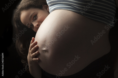 Canvas-taulu Beautiful little woman girl hugging pregnant mother's