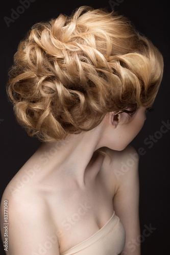 Portrait of a beautiful blond woman in the image of the bride. Picture taken in the studio on a black background. Beauty face. Hairstyle back view