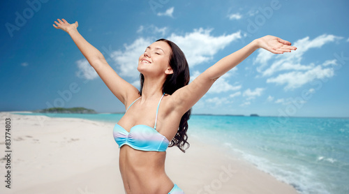 happy woman in bikini swimsuit with raised hands