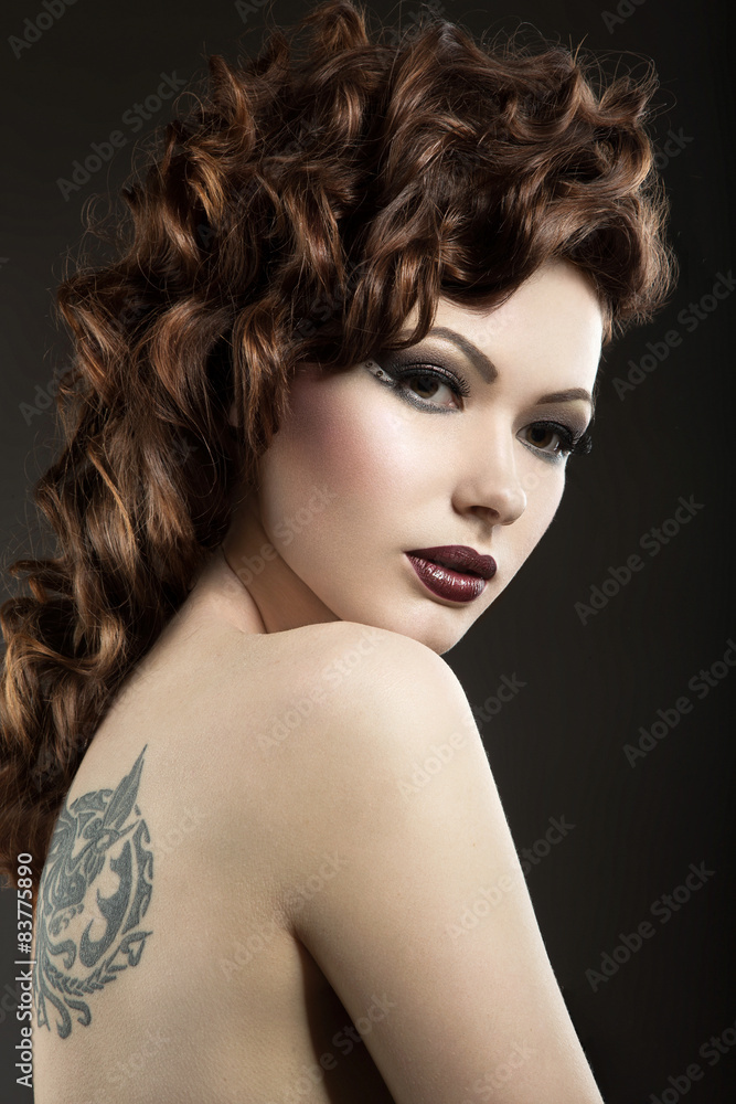 Beautiful girl with perfect skin and evening makeup. Picture taken in the studio on a black background