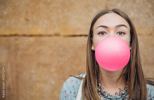 Valokuvatapetti Young teenage girl blowing pink bubble gum