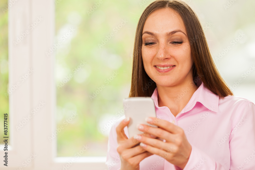 Smiling business woman is typing a message on her phone Smiling business woman is typing a message on her phone