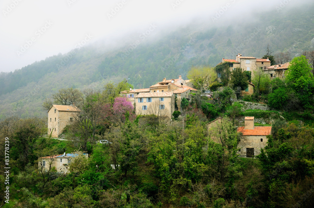 Fototapeta premium Remote French village on the hill under foggy weather.