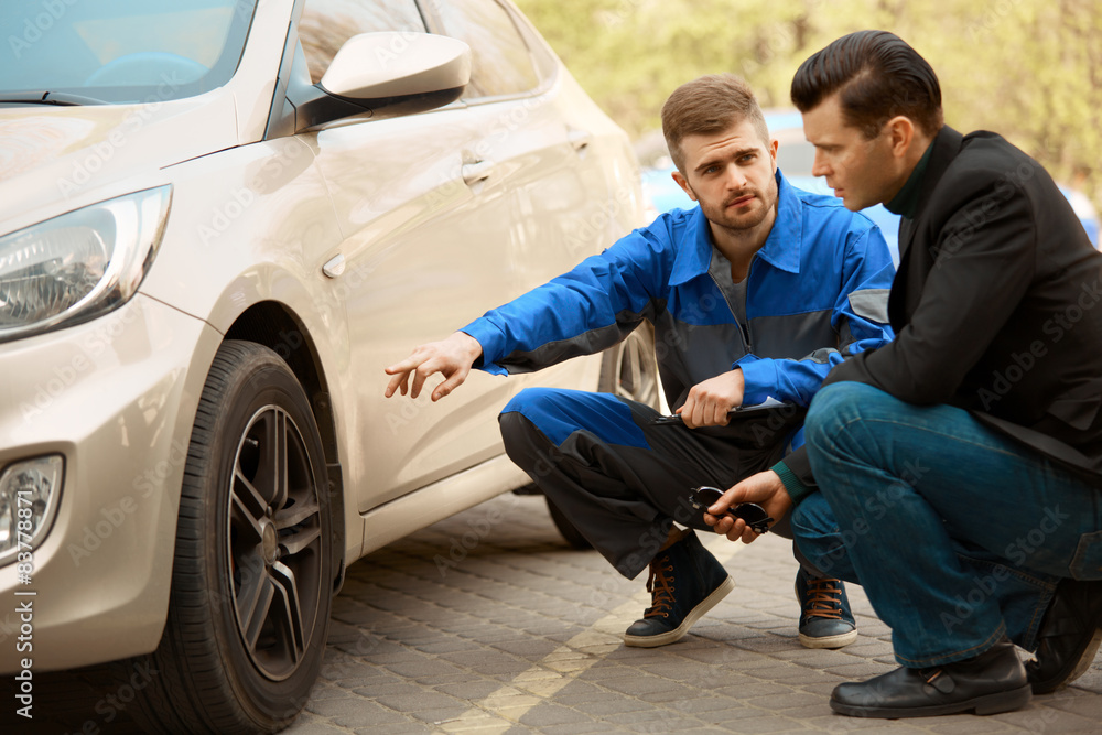 Mechanic and Customer Discussing Problem With Car. Mechanic and Customer Discussing Problem With Car.