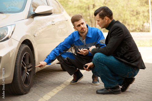 Mechanic and Customer Discussing Problem With Car. 