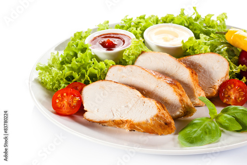 Roast chicken fillet and vegetables on white background