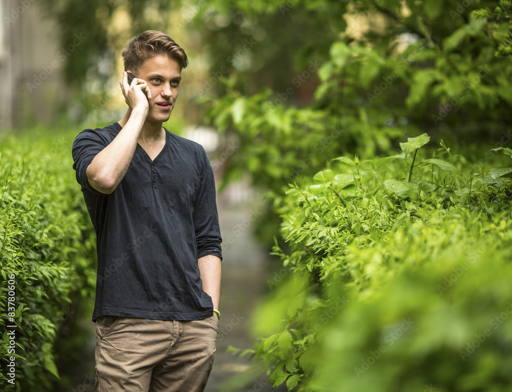 Young man talking on mobile phone outdoors. Young man talking on mobile phone outdoors.