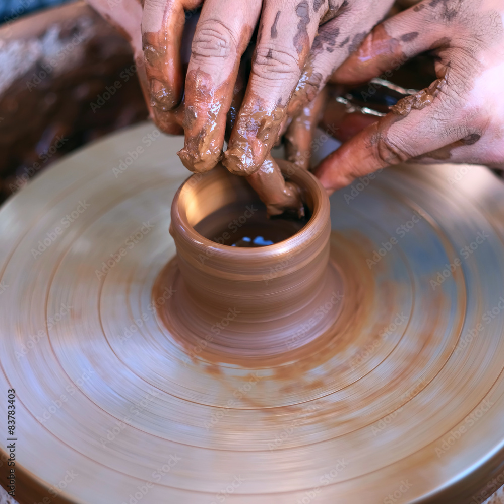 Fototapeta premium Hands working on pottery wheel