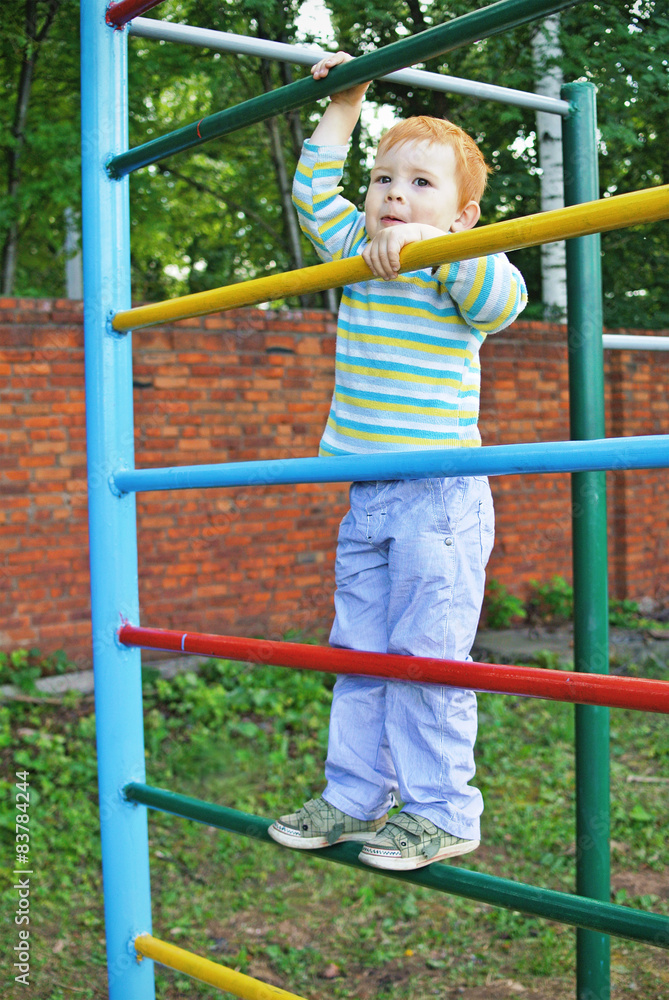 The little boy on swedish wall outdoors The little boy on swedish wall outdoors