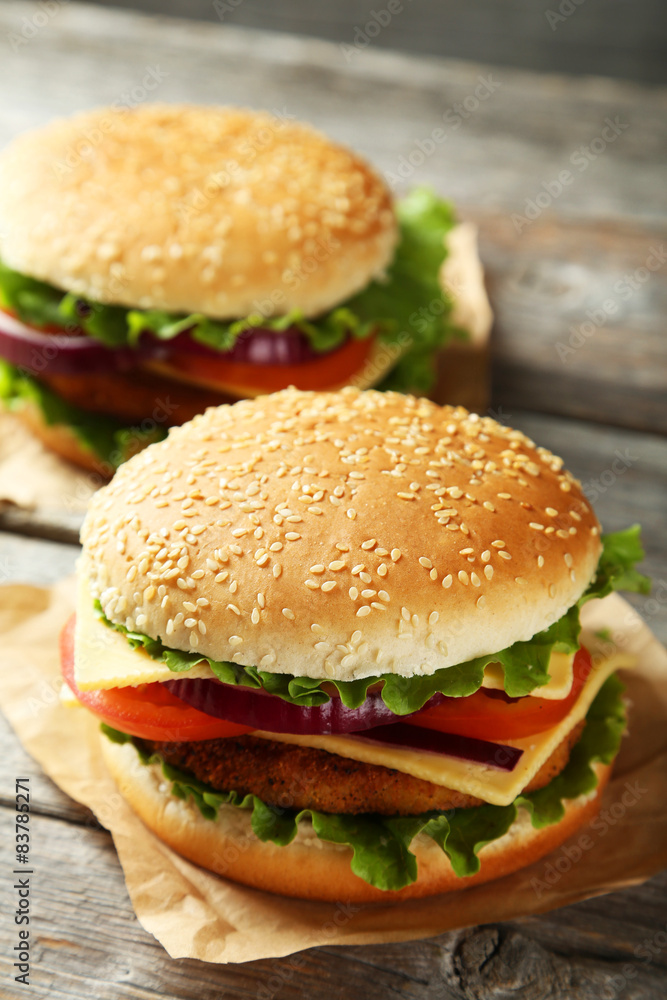 Fresh burgers on grey wooden background Fresh burgers on grey wooden background