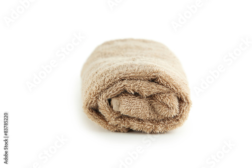 Rolled up beige towel isolated on white