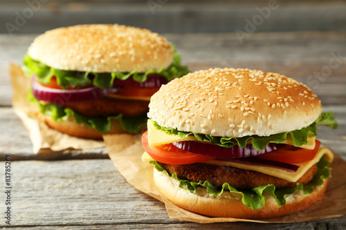Fresh burgers on grey wooden background