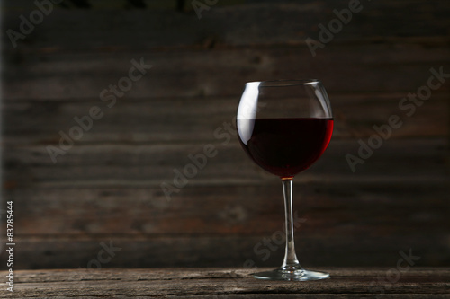Red wine glass on grey wooden background