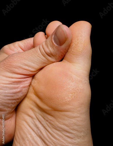Thumb pressure on big toe massage on dry skin isolated towards b