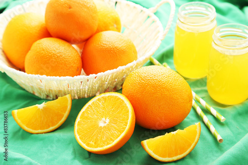 Orange juice in bottle and orange in basket 