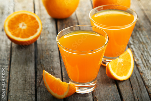 Glass of fresh orange juice on wooden background