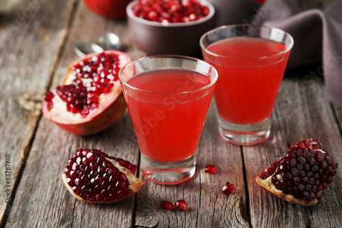 Pomegranate juice in glass on wooden background photo